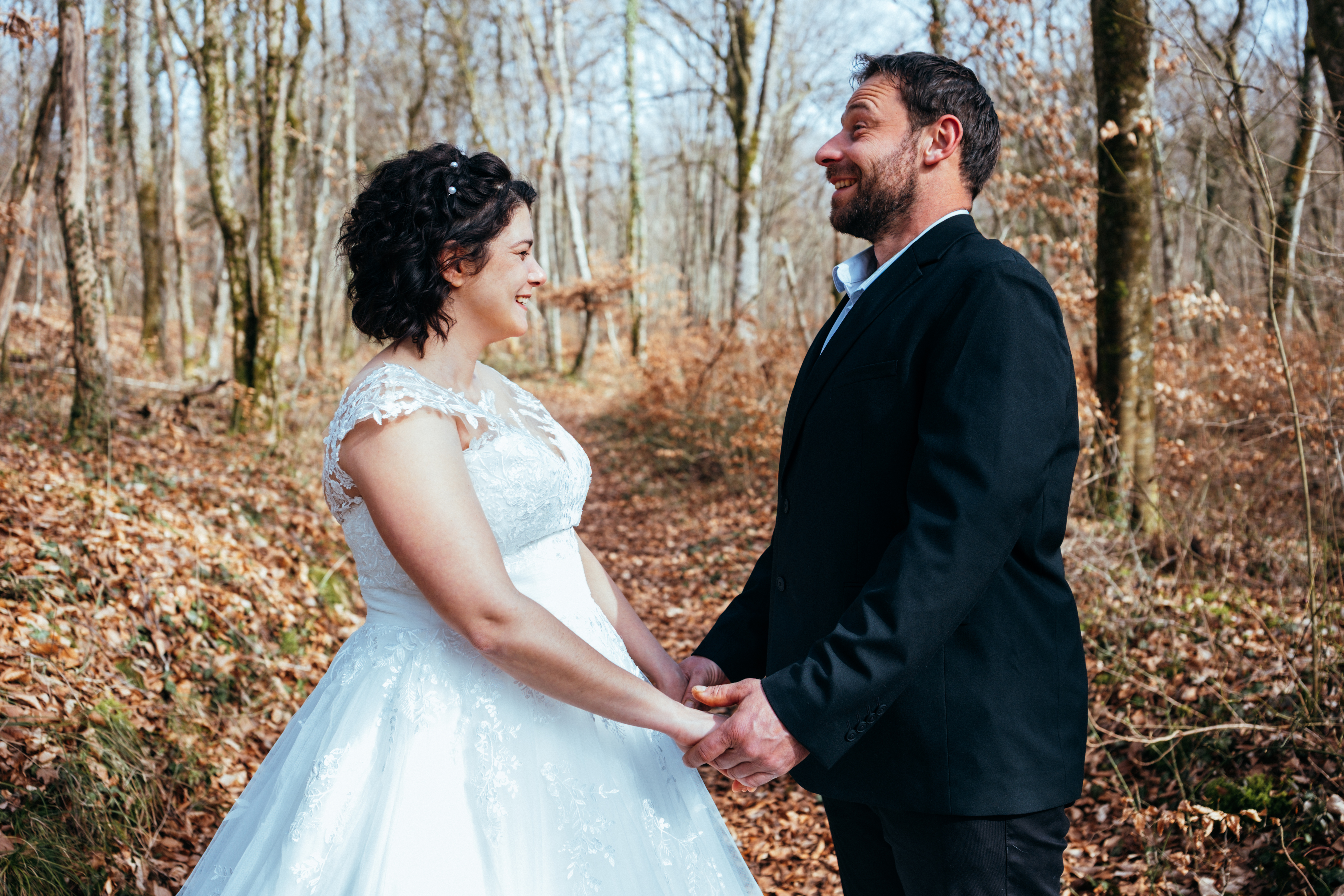 couple heureux dans une forêt habillé en mariés